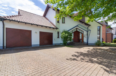 Großzügige Einfahrt, zwei Garagen und ein einladender Hauseingang – dieses Zuhause überzeugt schon beim ersten Eindruck.